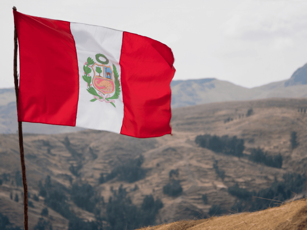 A Peruvian flag flies in the mountains.