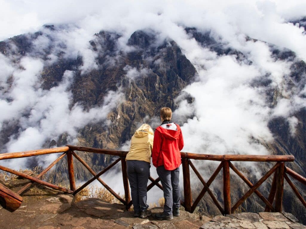 Tourists in Peru look at the mountains.