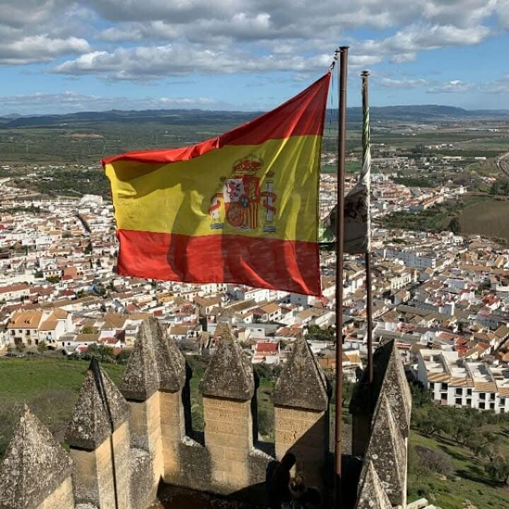 The Spanish flag flying over a castle.