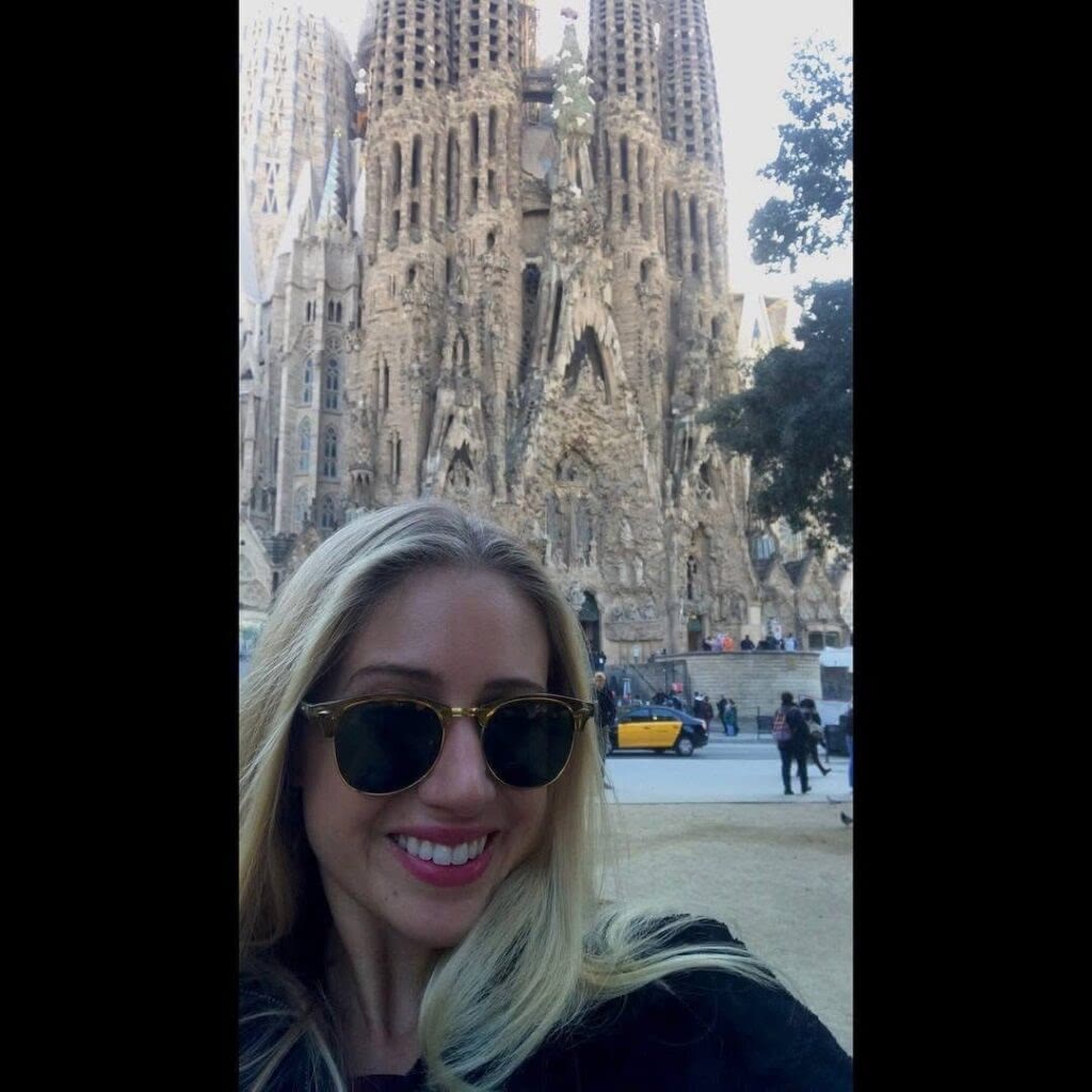 A blonde tourist poses in front of La Sagrada Familia in Barcelona, Spain.