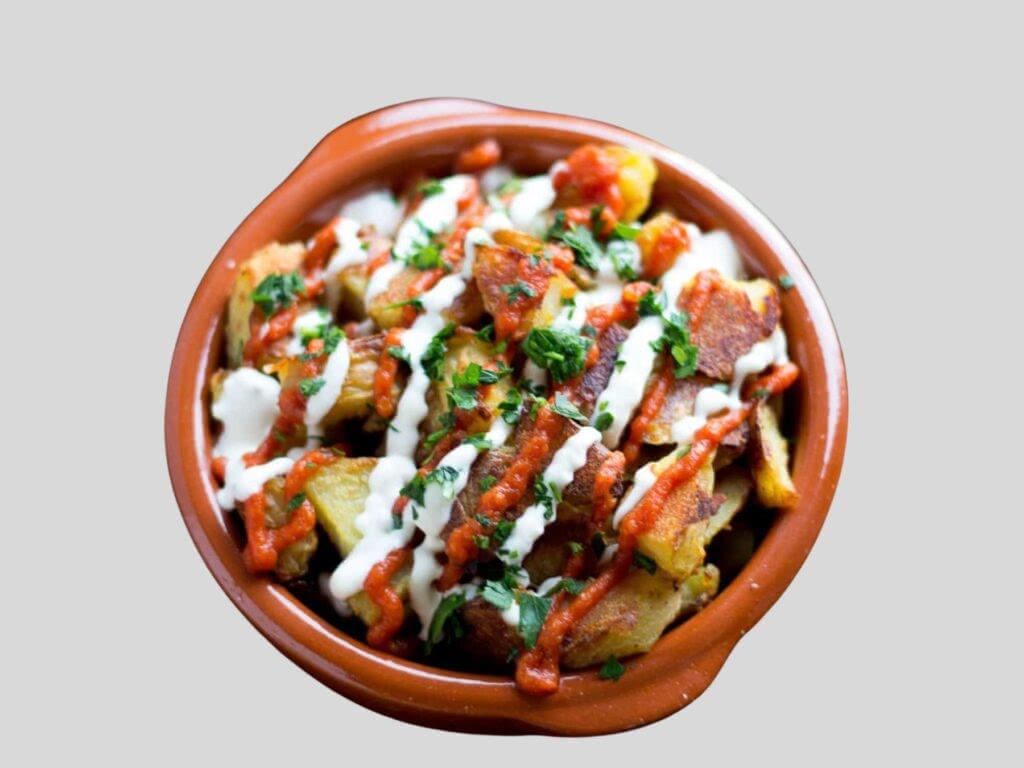 Patatas bravas covered in delicious sauces in Spain.